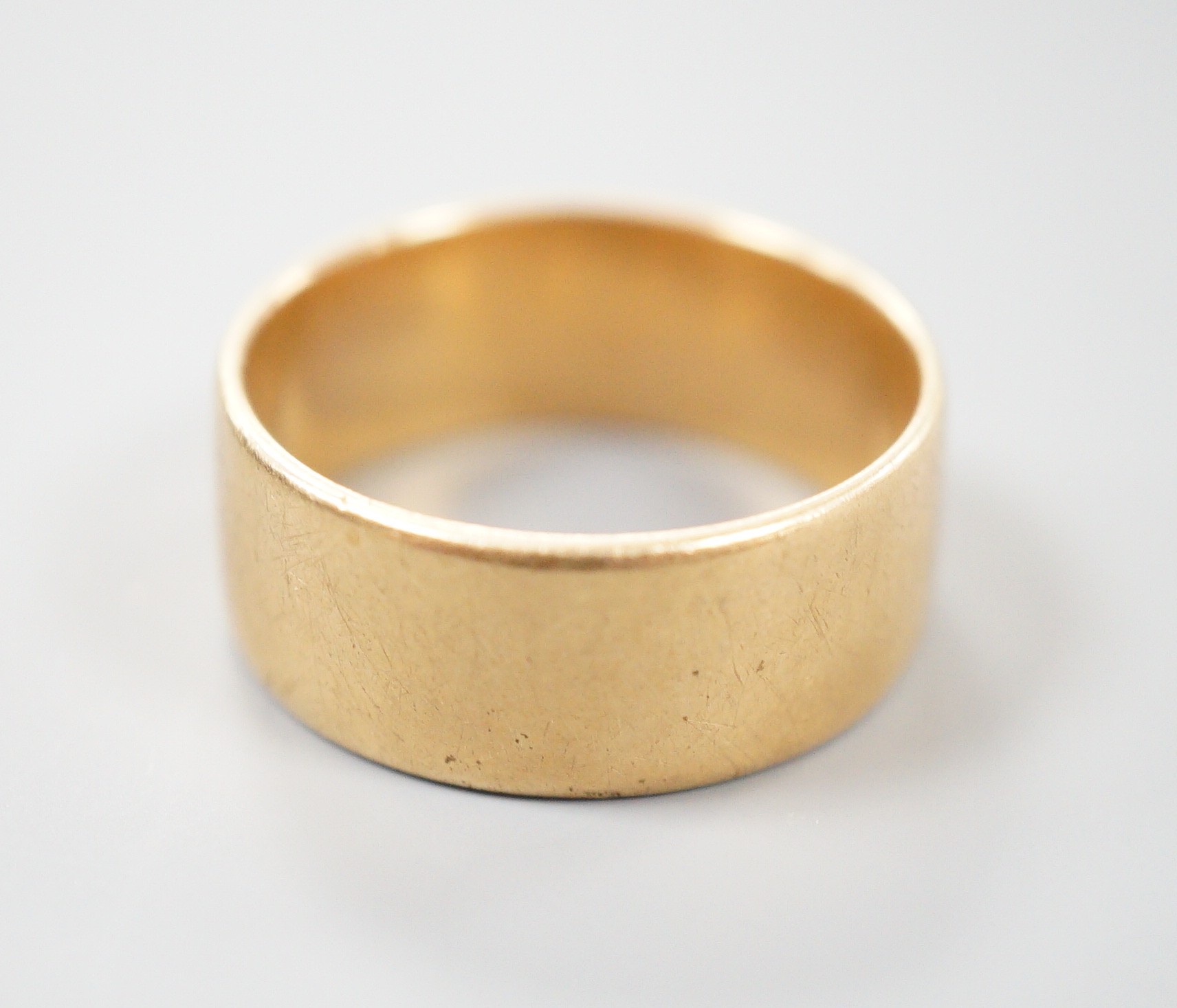 A yellow metal wedding band, unmarked, size P, 7.4 grams.